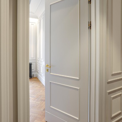Białe drzwi w przedpokoju, podłoga drewniana wykonana z materiałów wykończeniowych wnętrz.