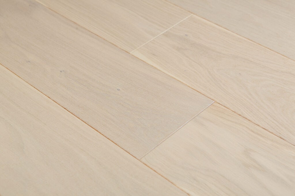 Zbliżenie na białą podłogę drewnianą wykonaną z deski warstwowej.